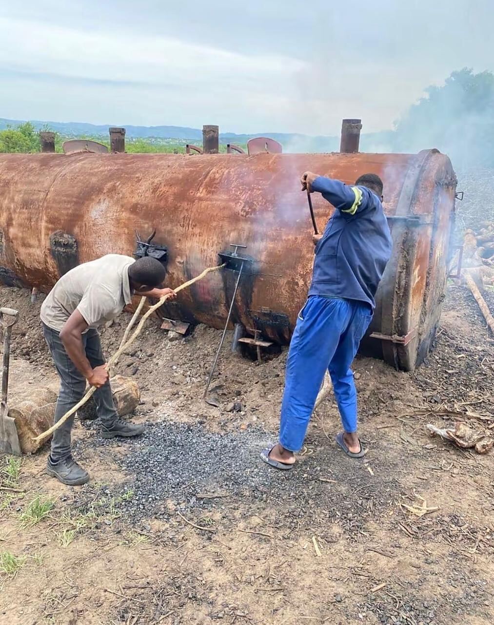 4 Brothers Coal production kiln with smoke rising from the charcoal-making process