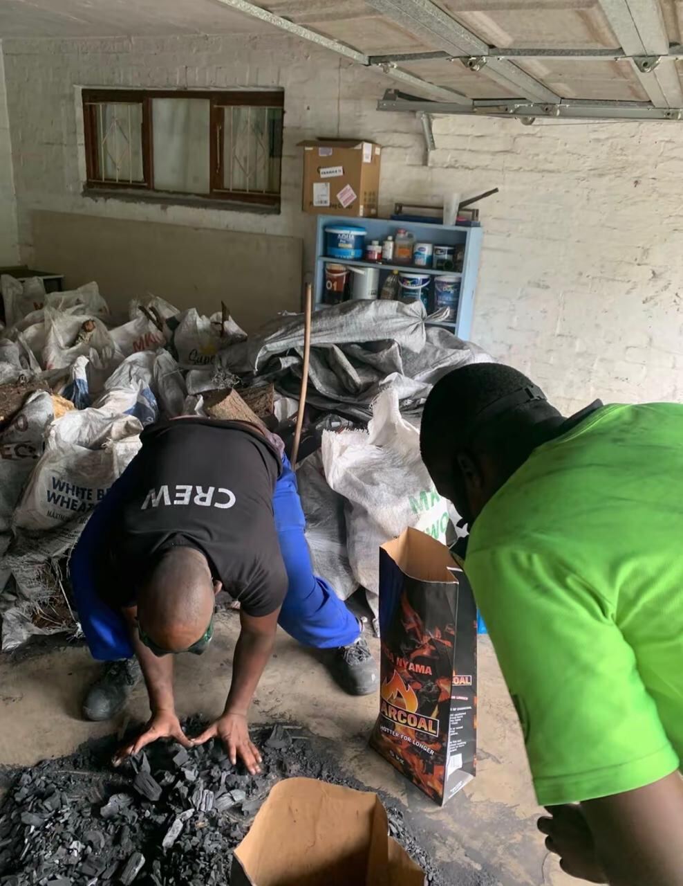 Two workers in a warehouse full of bagged stock